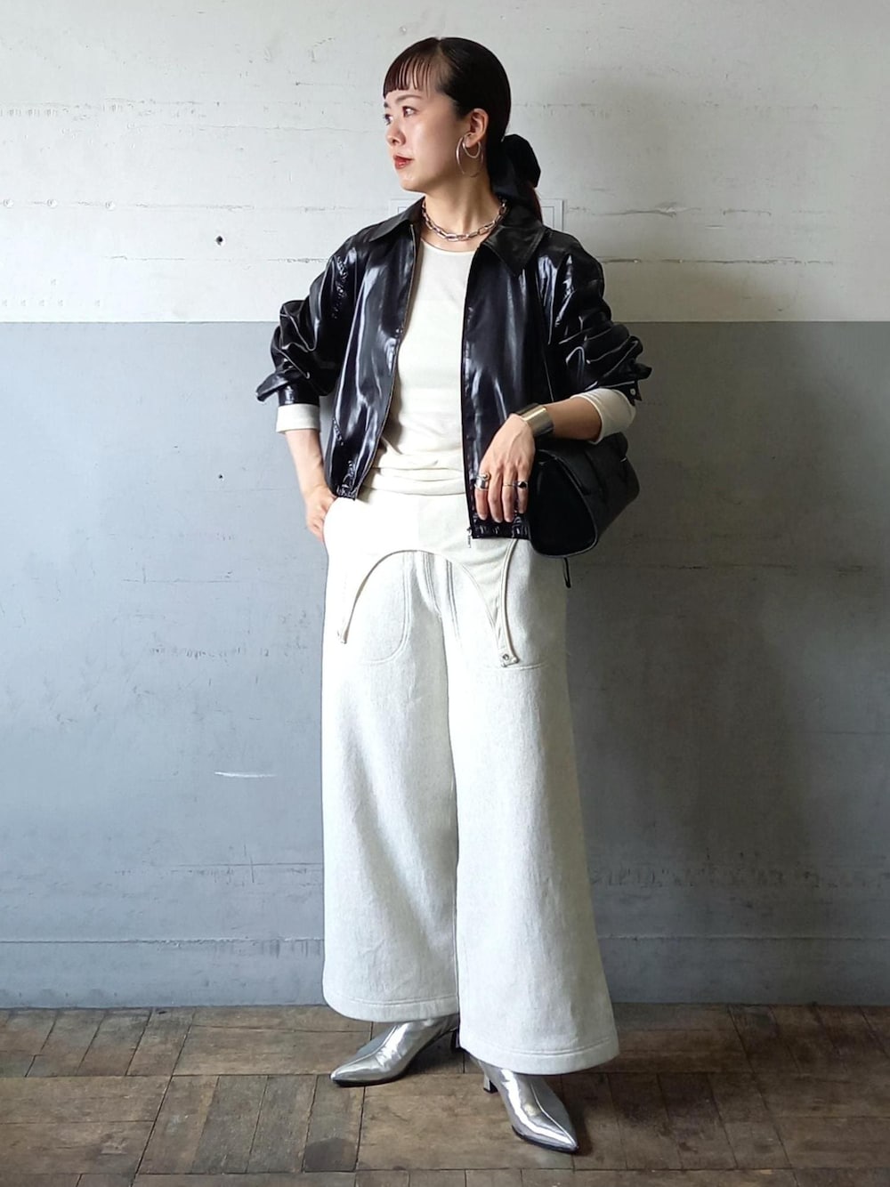 ブラック系のブルゾン、ホワイト系のTシャツ/カットソー、ブラック系のショルダーバッグを着用したレディースの秋コーディネートの1枚目の写真