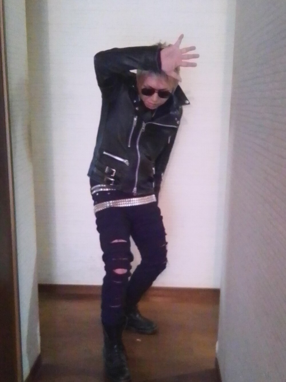 ブラック系のライダースジャケット、ブラック系のパンツ、ブラック系のブーツを着用したメンズの春コーディネートの2枚目の写真