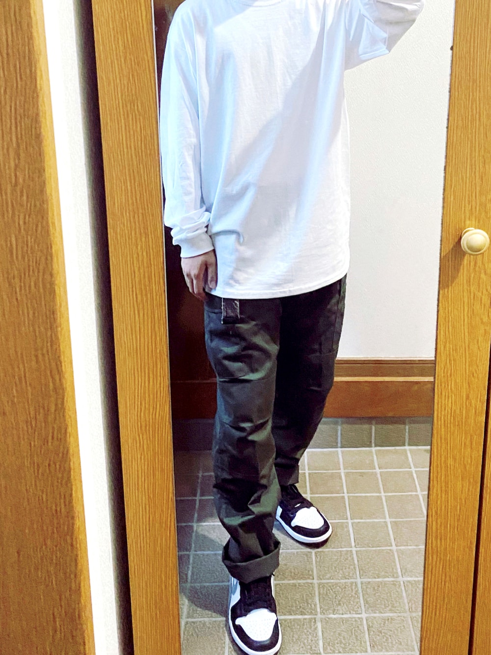 グリーン系のカーゴパンツ、ブラック系のスニーカー、ホワイト系のTシャツ/カットソーを着用したメンズの秋コーディネートの1枚目の写真
