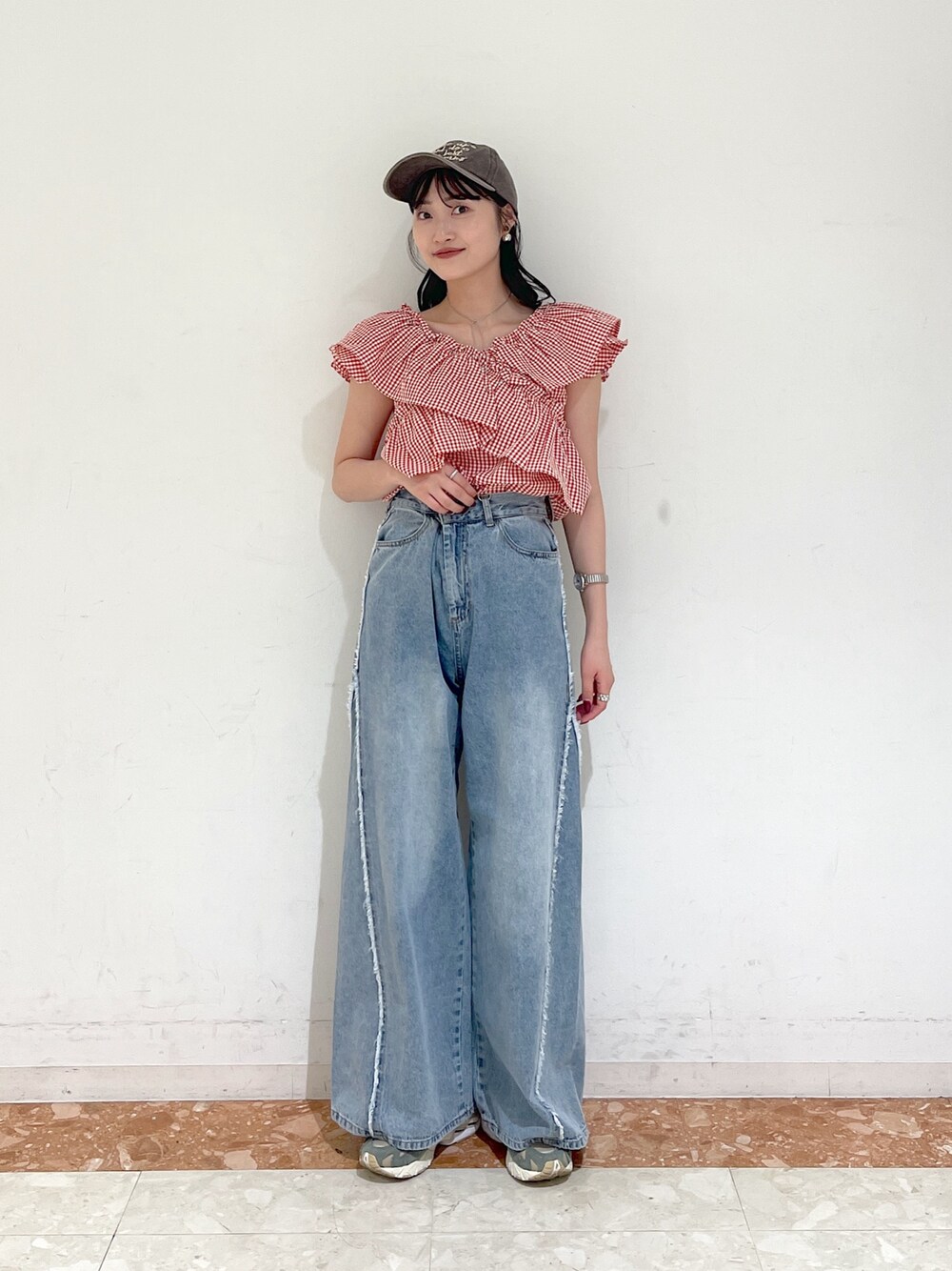 レッド系のシャツ/ブラウス、ブルー系のデニムパンツ、ブラウン系のキャップを着用したレディースの春コーディネートの1枚目の写真