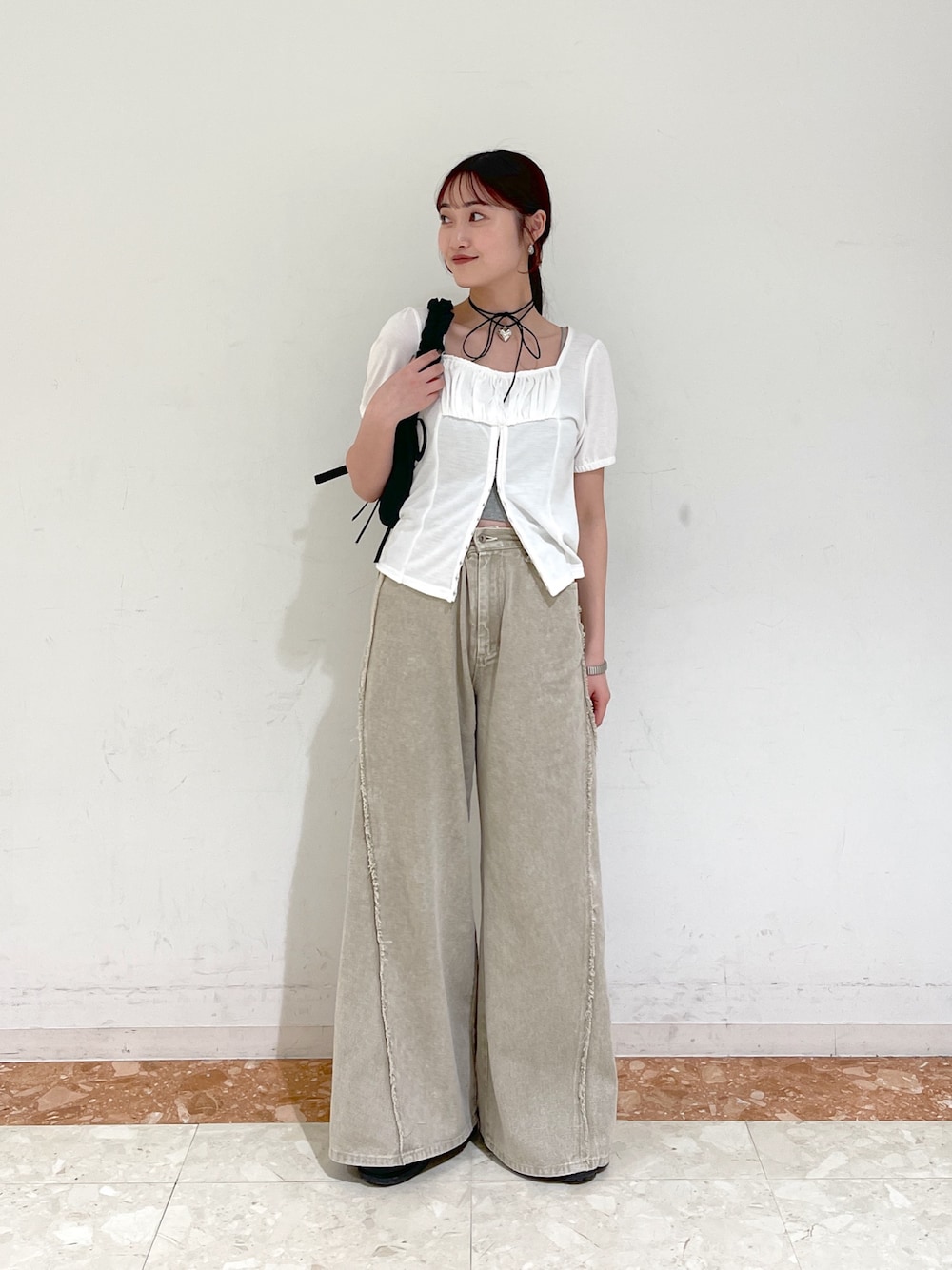 ホワイト系のTシャツ/カットソー、ベージュ系のデニムパンツ、ブラック系のショルダーバッグを着用したレディースの春コーディネートの1枚目の写真