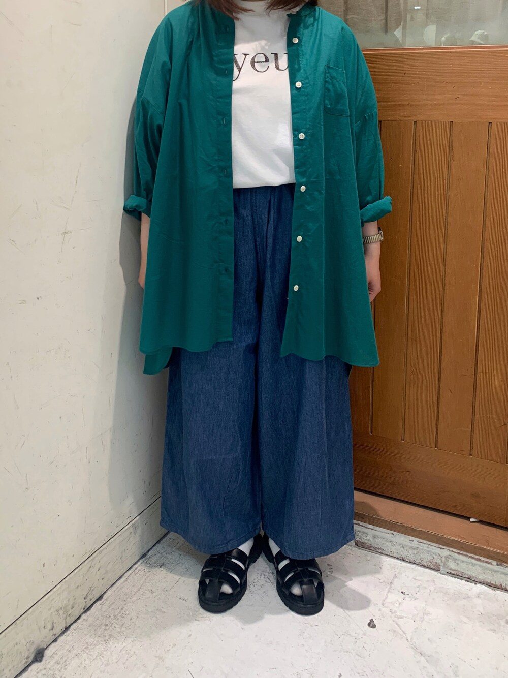 ブラック系のサンダル、ホワイト系のTシャツ/カットソー、グリーン系のシャツ/ブラウスを着用したレディースの春コーディネートの1枚目の写真