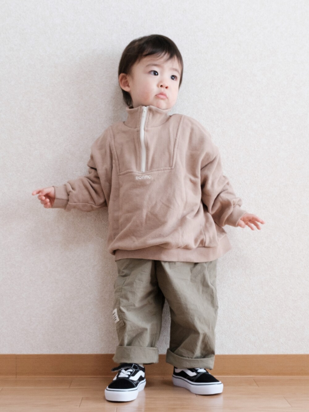 グリーン系のサロペット/オーバーオール、ブラック系のスニーカー、ベージュ系のスウェットを着用したキッズの春コーディネートの1枚目の写真