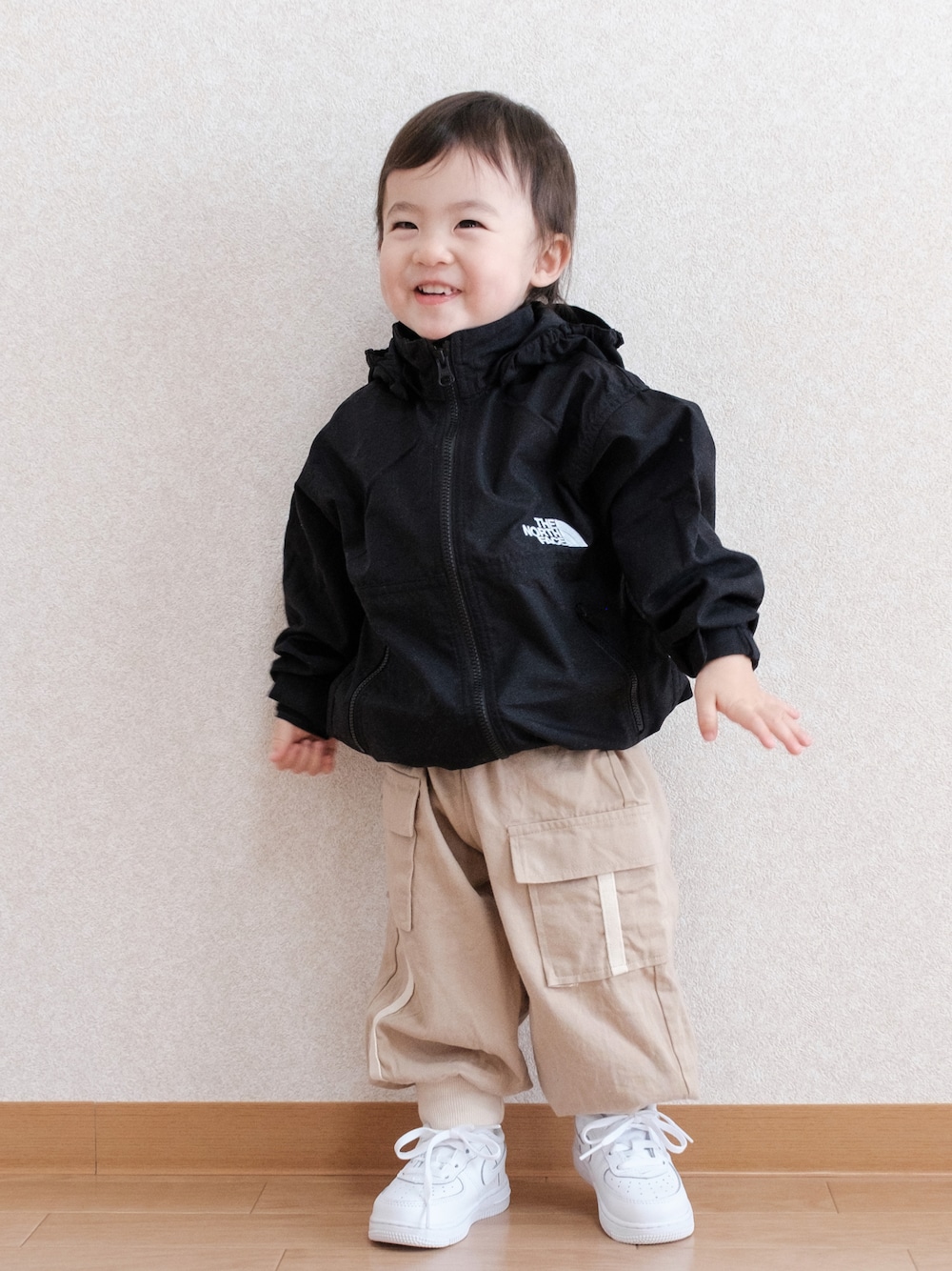 「ボリューム袖、マウンテンパーカー、ナイロンジャケット、ノースフェイス、カーゴパンツ、白スニーカー、NIKE、春コーデ、春アウター、1歳、キッズファッション」｜「THE NORTH FACEのTHE NORTH FACE/ザ・ノース・フェイス/COMPACT JACKET/コンパクトジャケット/KIDS/ｷｯｽﾞ/NPJ22210/COMPACT JACKET（ナイロンジャケット、ブラック系）」を使った、ITSUKIさん（キッズ・80cm）の春コーディネートの1枚目の写真