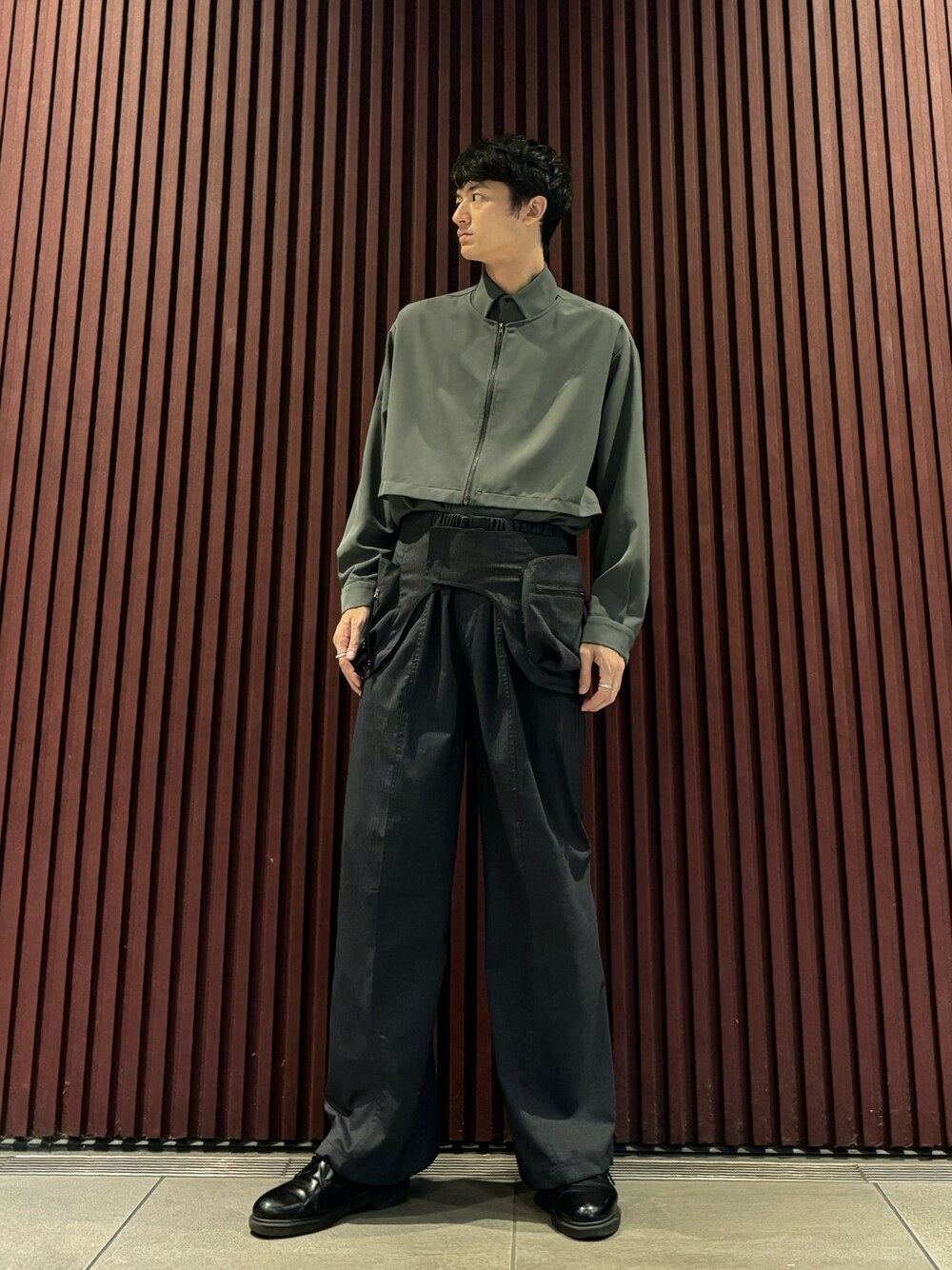 グレー系のスラックス、グリーン系のシャツ/ブラウス、ブラック系のドレスシューズを着用したメンズの秋コーディネートの1枚目の写真