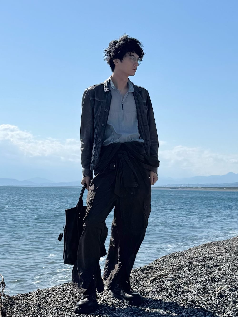「春コーデ、モードカジュアル、大人カジュアル、Aライン、ヴィンテージ、レザー、レザージャケット、ジャンプスーツ、ワイドパンツ、海」｜「PUBLIC TOKYOのシアーリップストップサマーベスト（ベスト、ブルー系）」を使った、TAK/差別化コーデさん（骨格ナチュラル・メンズ・183cm）の春コーディネートの1枚目の写真