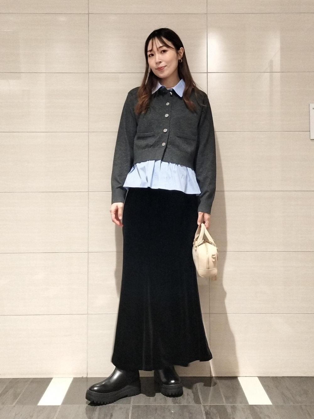 ベージュ系のボストンバッグ、ブラック系のブーツ、ブラウン系のキャミソールを着用したレディースの秋コーディネートの1枚目の写真