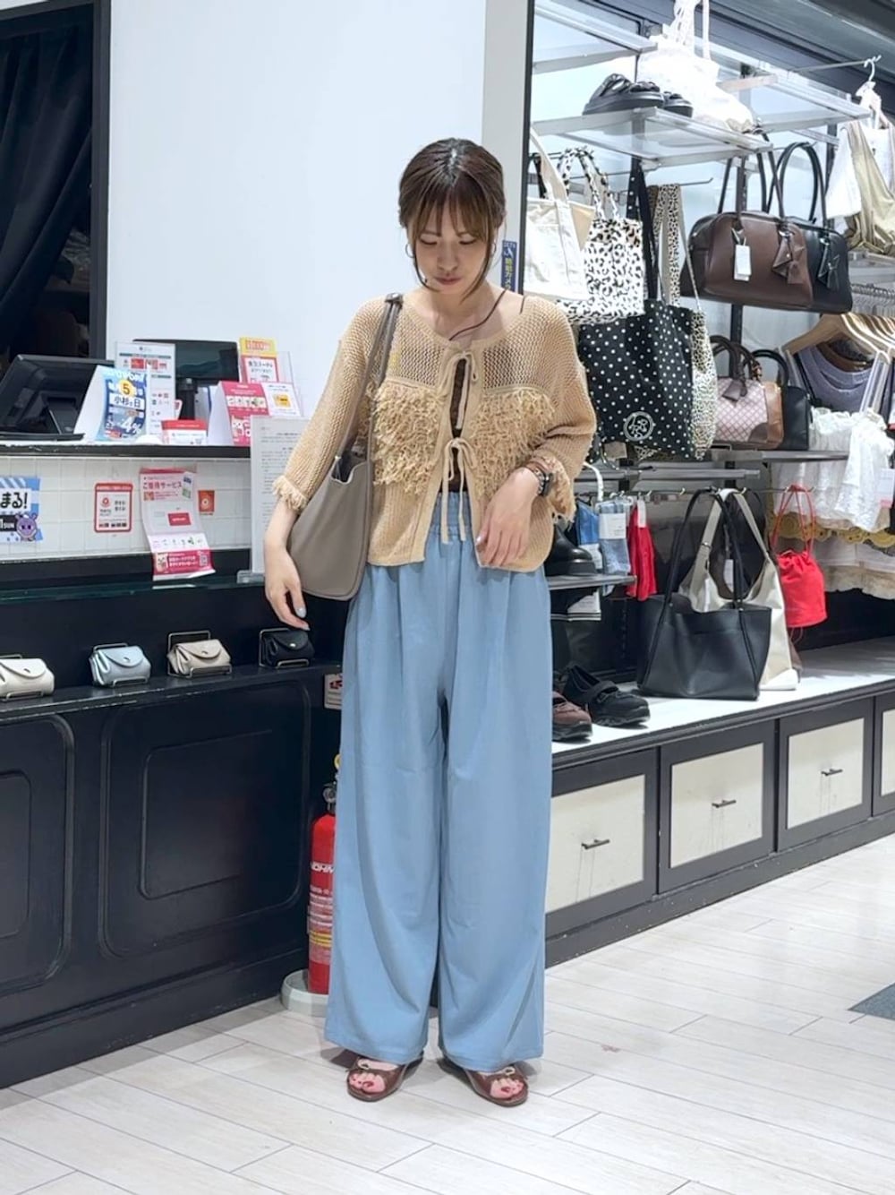 ブラウン系のサンダル、ベージュ系のカーディガン/ボレロ、ベージュ系のショルダーバッグを着用したレディースの夏コーディネートの1枚目の写真