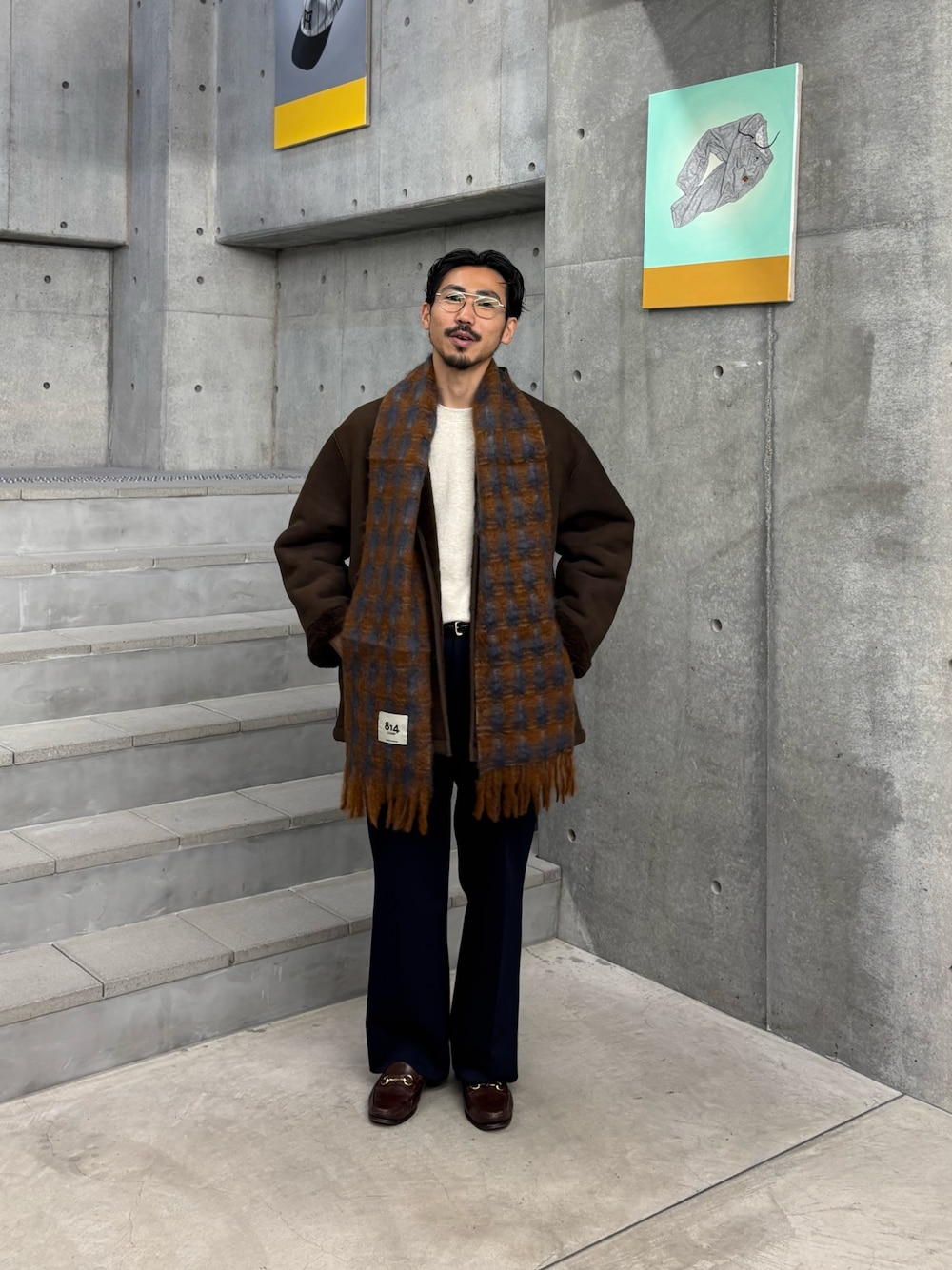 ブラウン系のその他アウター、ブルー系のその他パンツ、グレー系のマフラーを着用したメンズの秋コーディネートの1枚目の写真