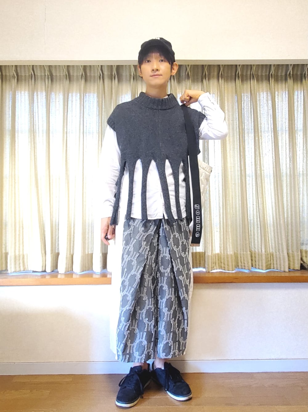 ブラック系のスニーカー、ブラック系のその他パンツ、グレー系のニット/セーターを着用したメンズの冬コーディネートの1枚目の写真