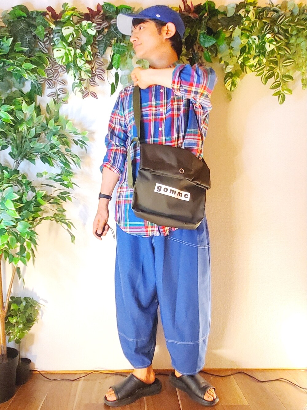 ブラック系のサンダル、ブルー系のその他パンツ、グリーン系のショルダーバッグを着用したメンズの夏コーディネートの1枚目の写真