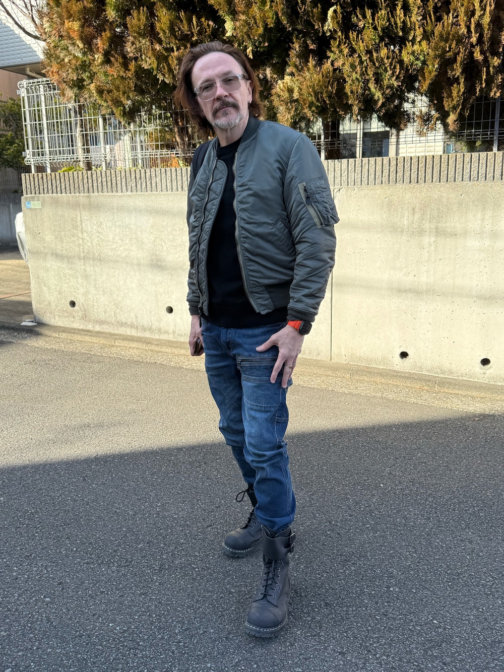 ブルー系のデニムパンツ、グリーン系のMA-1、ブラック系のニット/セーターを着用したメンズの冬コーディネートの1枚目の写真