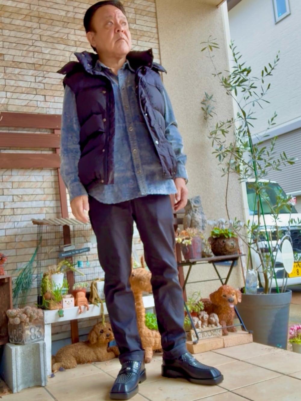 ブラック系のデニムパンツ、シルバー系のシャツ/ブラウス、ブラック系のダウンベストを着用したメンズの秋コーディネートの1枚目の写真