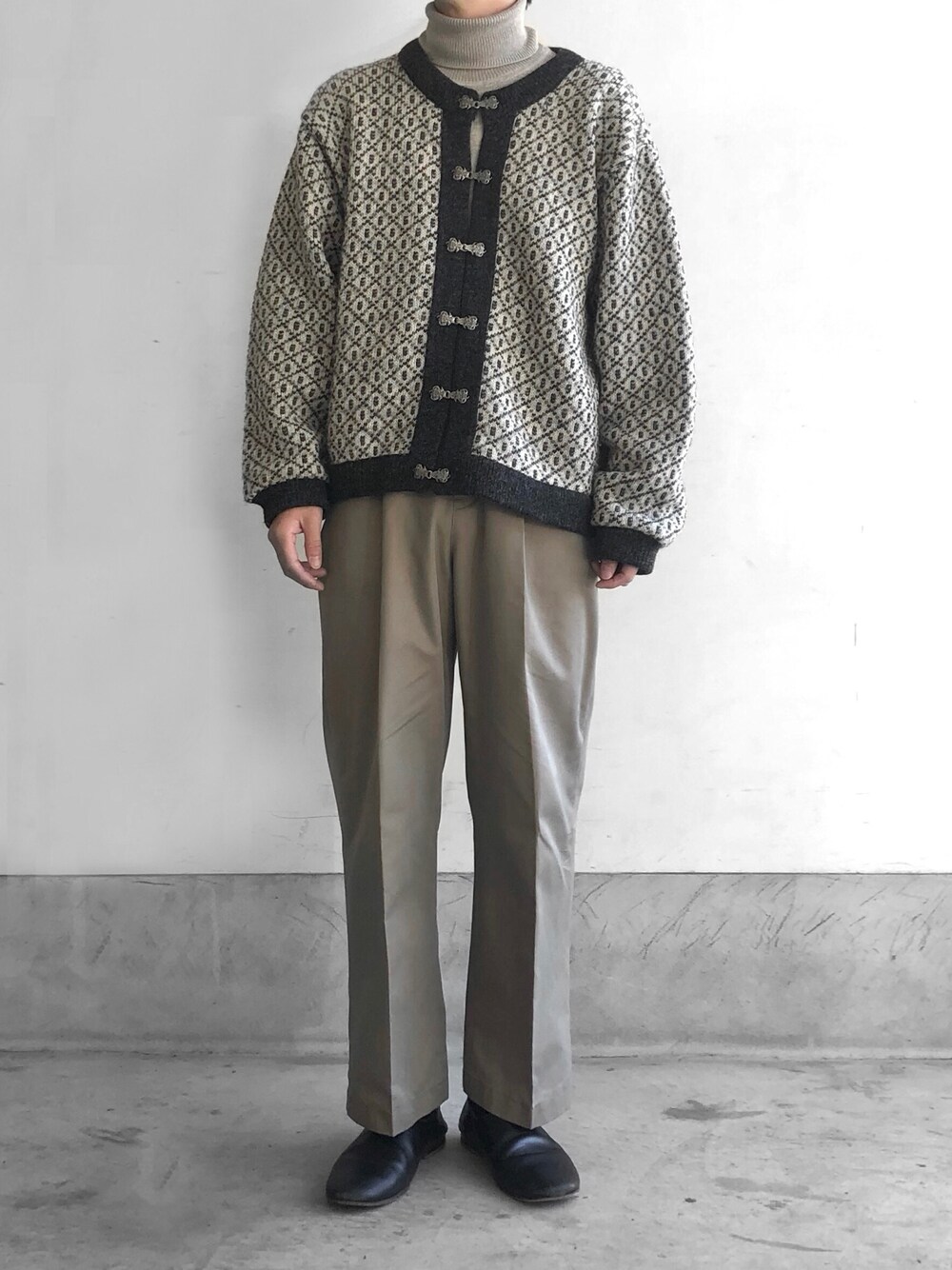 ベージュ系のニット/セーター、ベージュ系のスラックス、ブラック系のスリッポンを着用したメンズの冬コーディネートの1枚目の写真