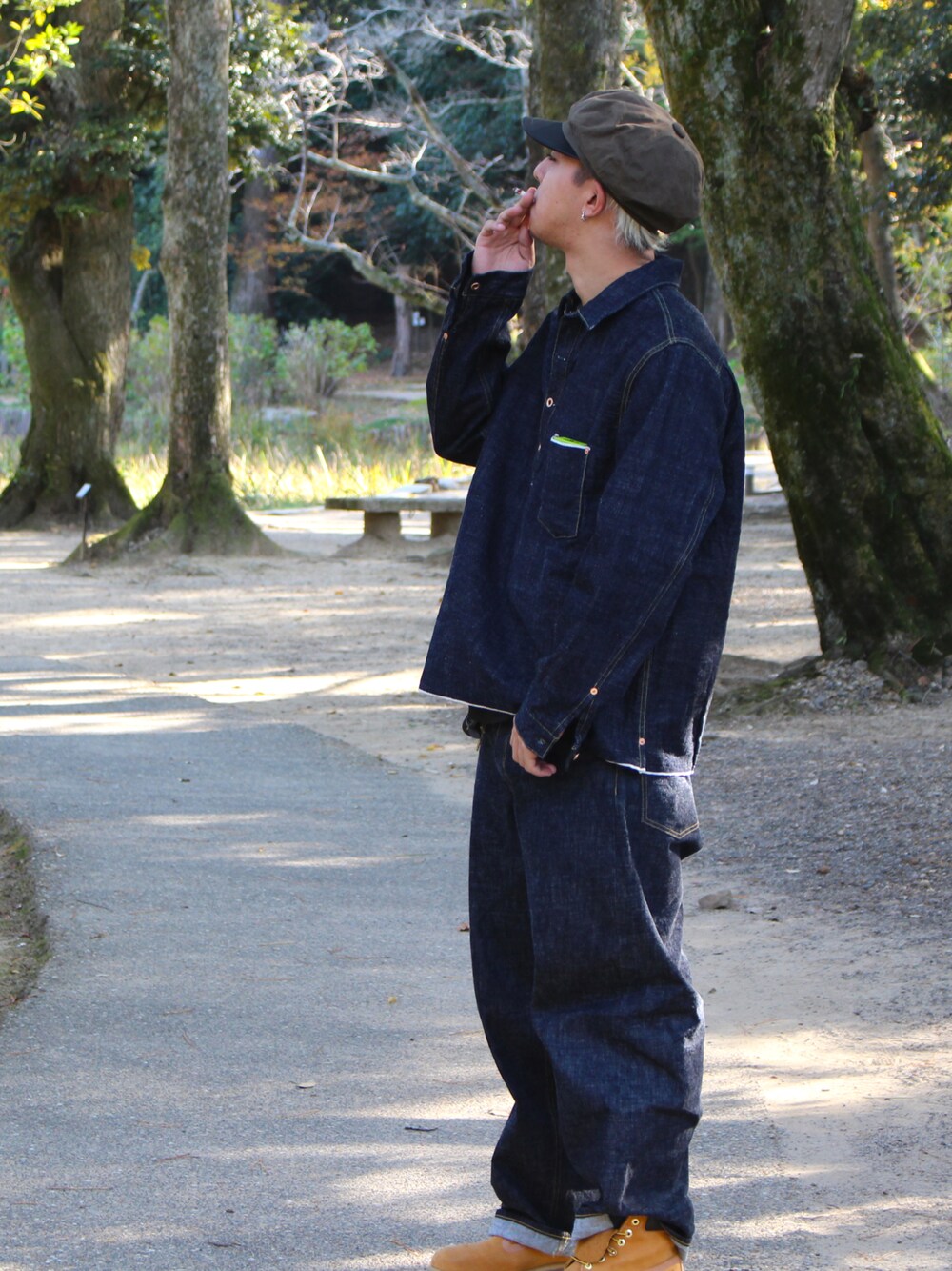 ブラック系のデニムジャケット、イエロー系のブーツ、ブラック系のデニムパンツを着用したメンズの秋コーディネートの1枚目の写真