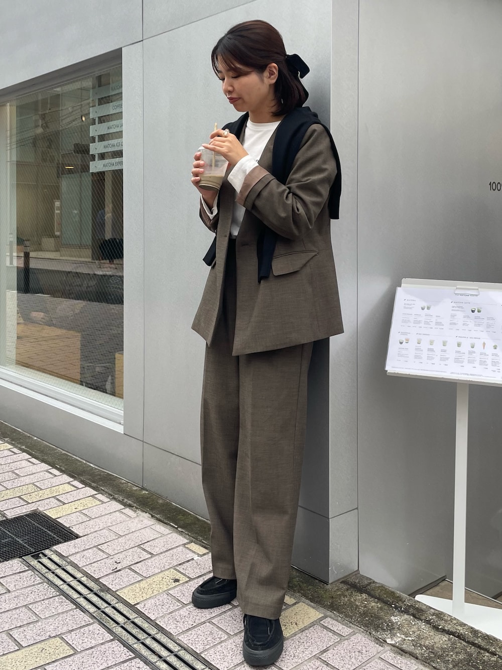 ブラウン系のスラックス、ブラウン系のノーカラージャケット、ホワイト系のTシャツ/カットソーを着用したレディースの秋コーディネートの1枚目の写真