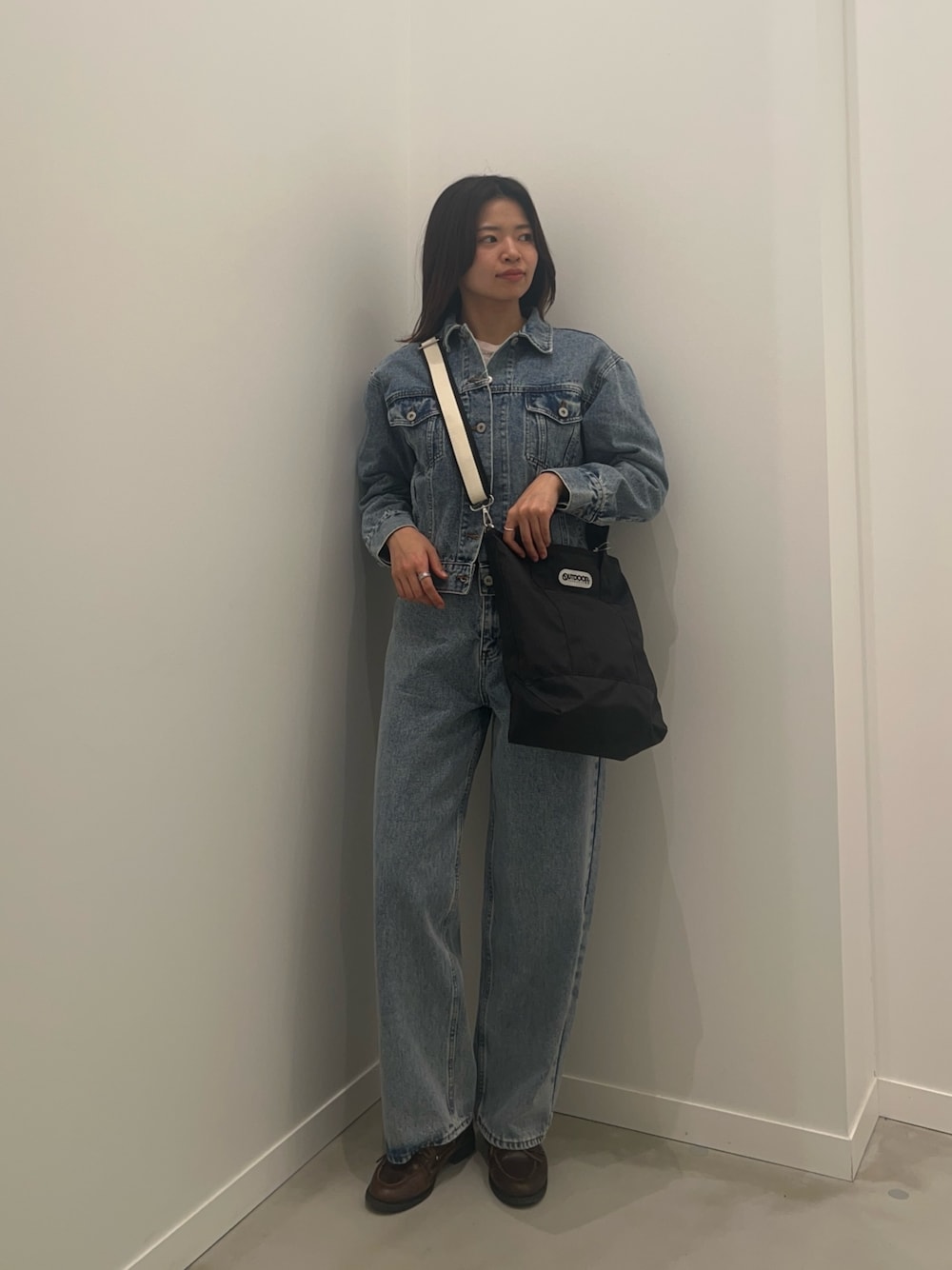 ブルー系のデニムジャケット、ブルー系のデニムパンツ、ブラウン系のベルトを着用したレディースの冬コーディネートの1枚目の写真