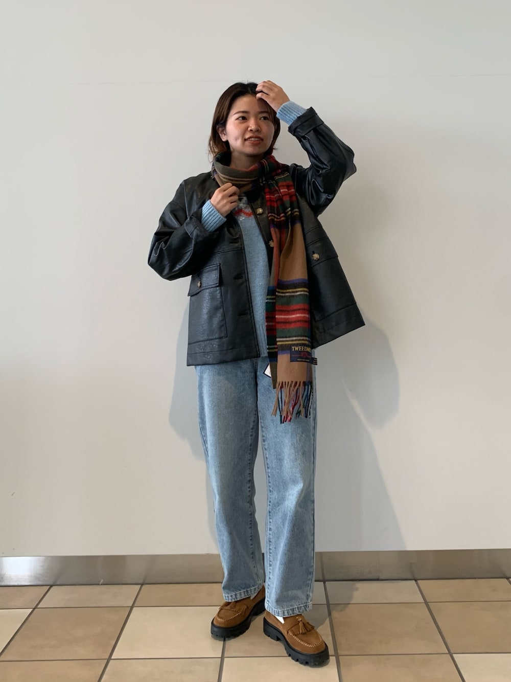 ブルー系のデニムパンツ、ブラック系のブルゾン、ブルー系のニット/セーターを着用したレディースの秋コーディネートの1枚目の写真