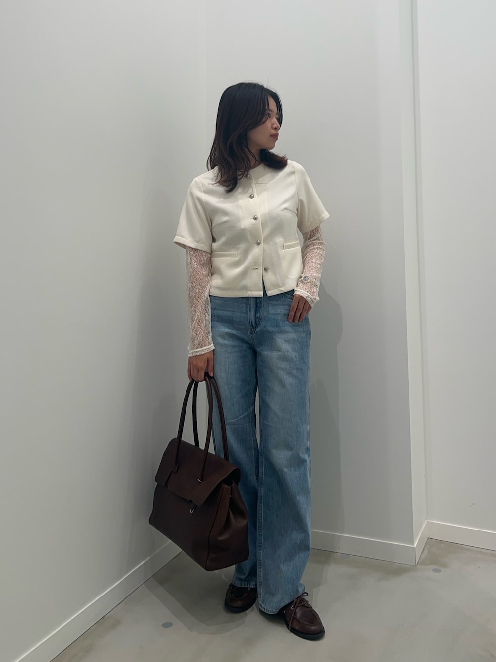 ブルー系のデニムパンツ、ホワイト系のTシャツ/カットソー、ホワイト系のノーカラージャケットを着用したレディースの春コーディネートの1枚目の写真