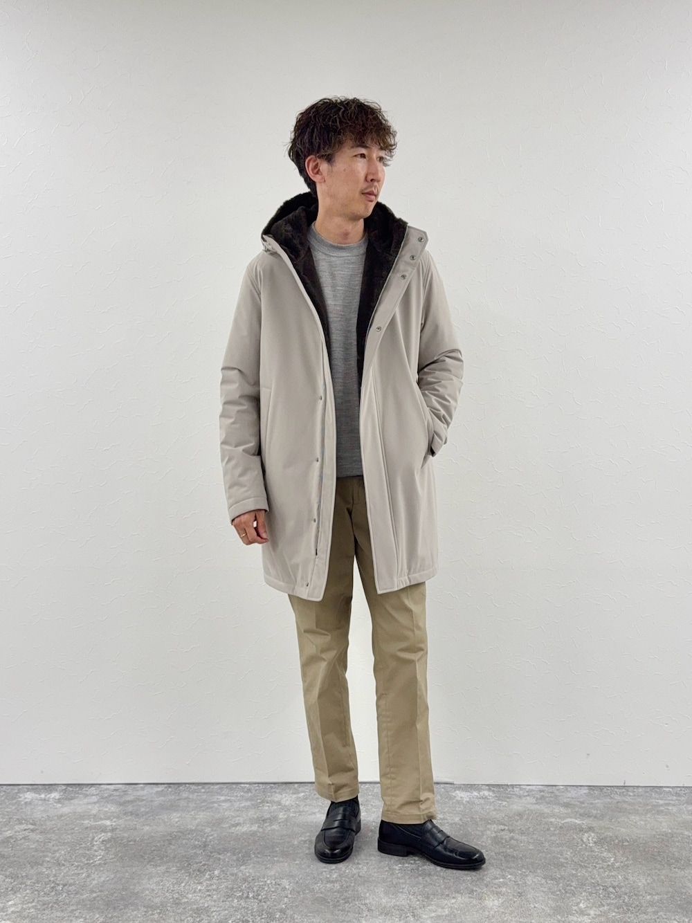 グレー系のニット/セーター、ベージュ系のその他アウター、ブラック系のローファーを着用したメンズの秋コーディネートの1枚目の写真
