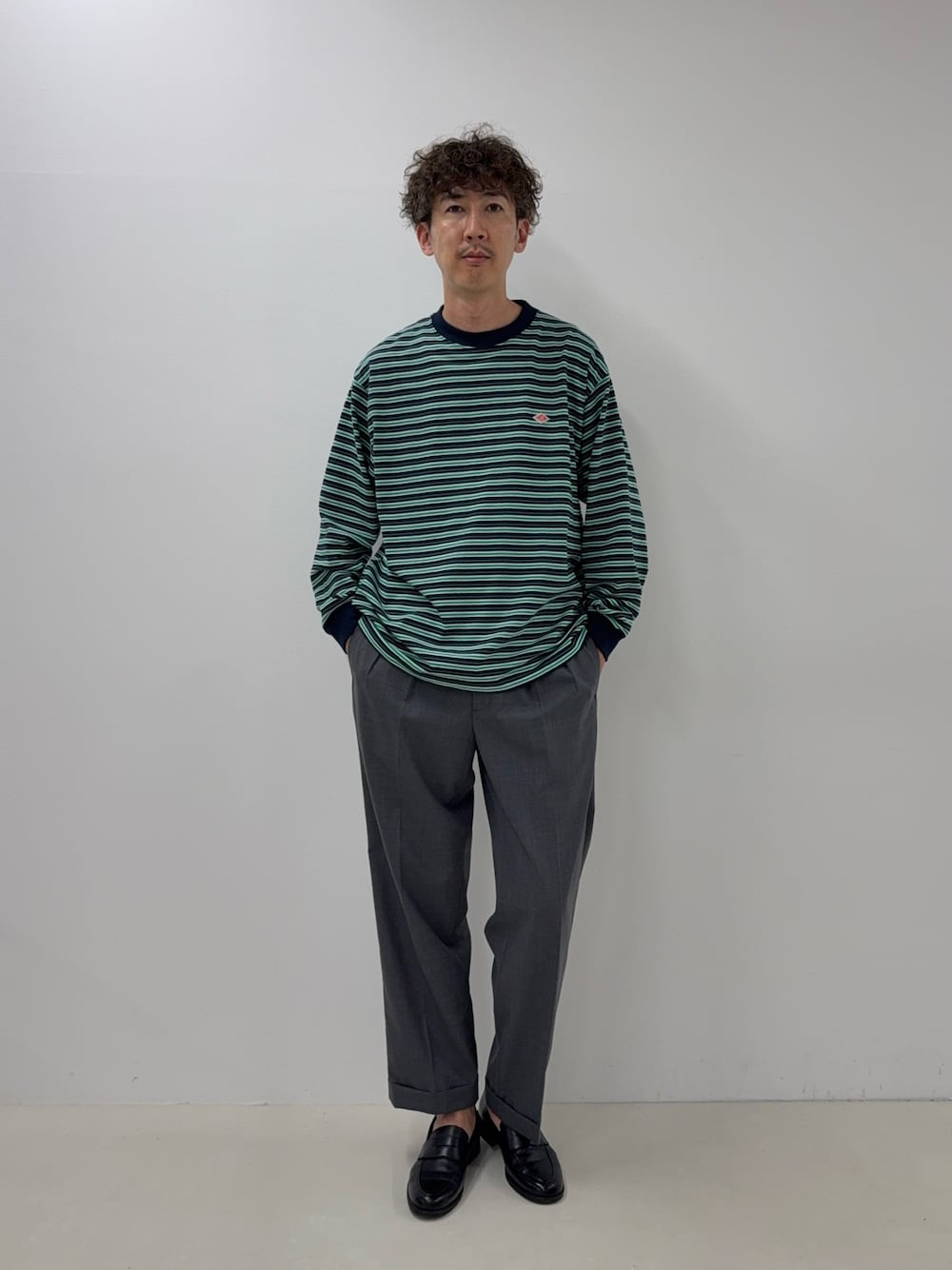 ブルー系のTシャツ/カットソー、グレー系のスラックス、ブラック系のローファーを着用したメンズの夏コーディネートの1枚目の写真