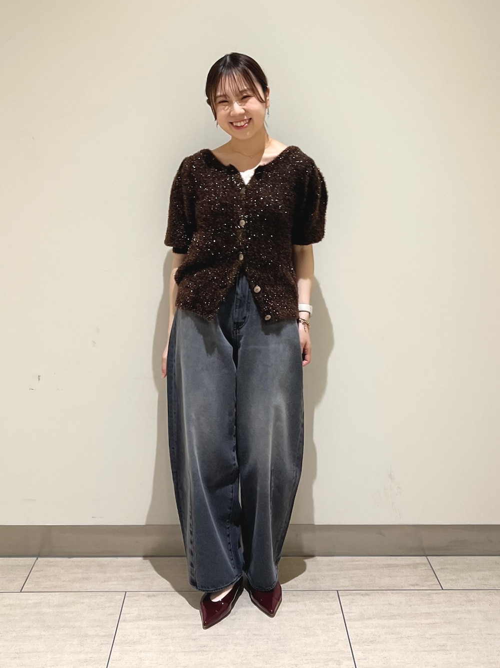 ブラック系のデニムパンツ、ブラウン系のニット/セーターを着用したレディースの秋コーディネートの1枚目の写真