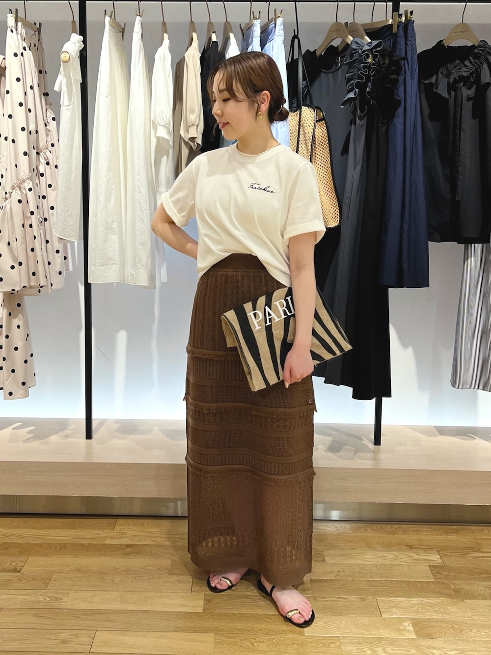 ホワイト系のTシャツ/カットソー、ブラウン系のスカートを着用したレディースの夏コーディネートの1枚目の写真