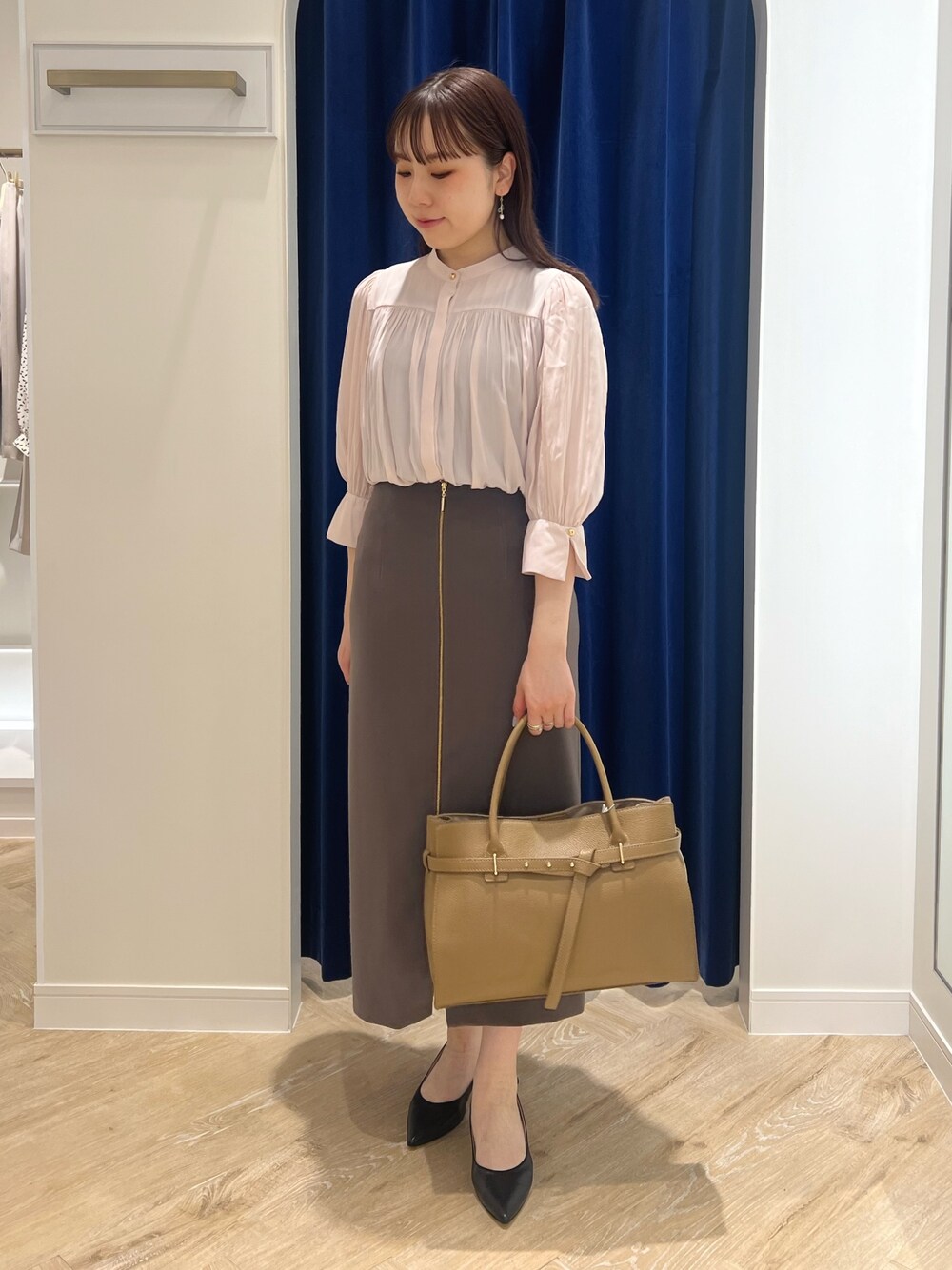 ブラウン系のスカート、ピンク系のシャツ/ブラウス、ブラック系のトートバッグを着用したレディースの春コーディネートの1枚目の写真