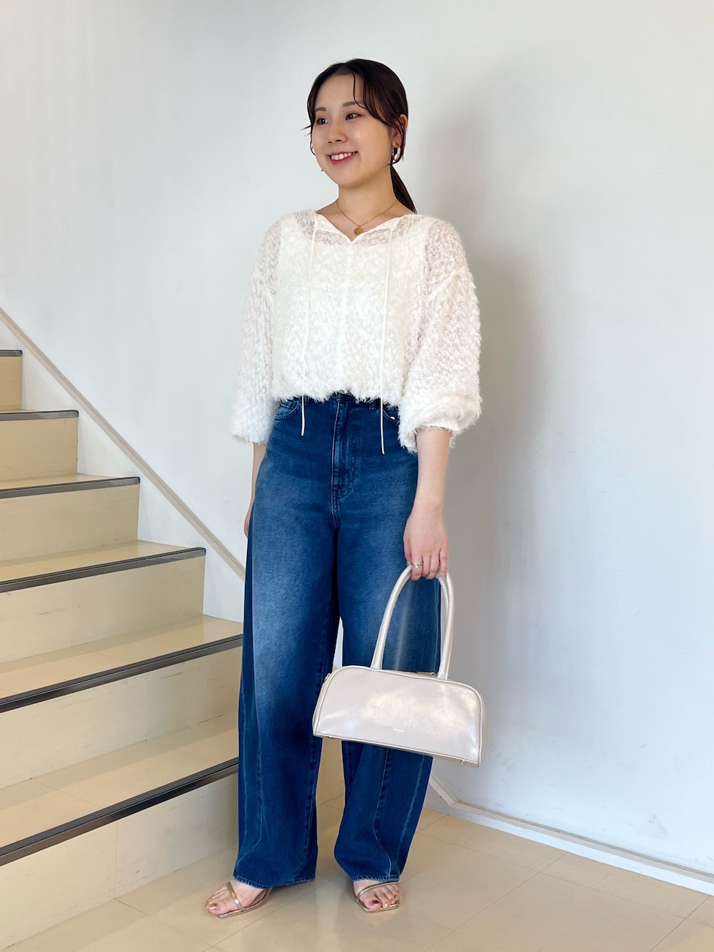 ブルー系のデニムパンツ、ホワイト系のシャツ/ブラウス、ホワイト系のボストンバッグを着用したレディースの夏コーディネートの1枚目の写真