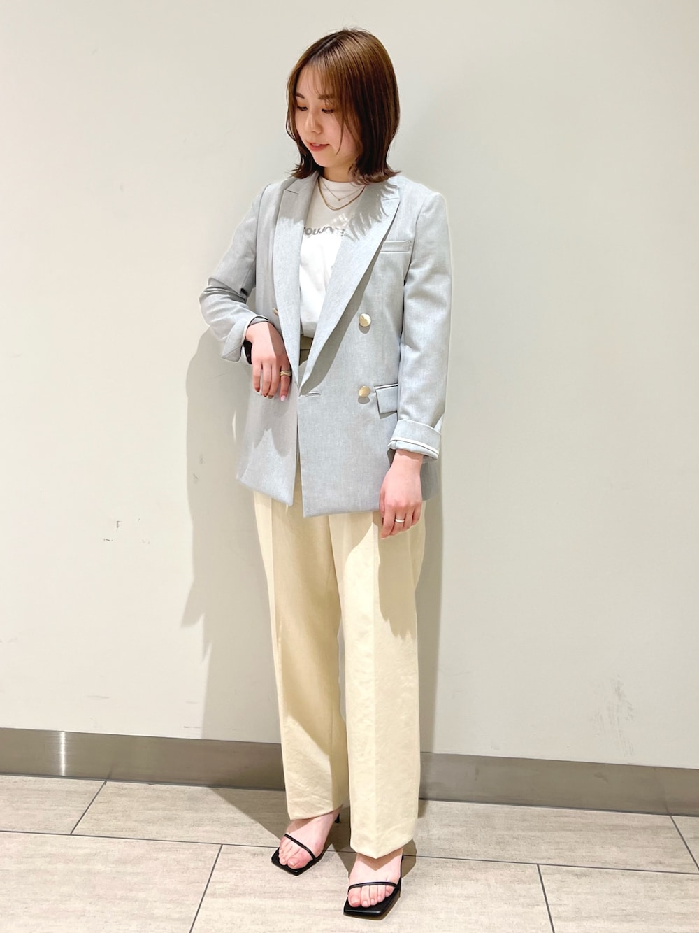 グレー系のテーラードジャケット、ベージュ系のその他パンツ、ブラック系のサンダルを着用したレディースの春コーディネートの1枚目の写真