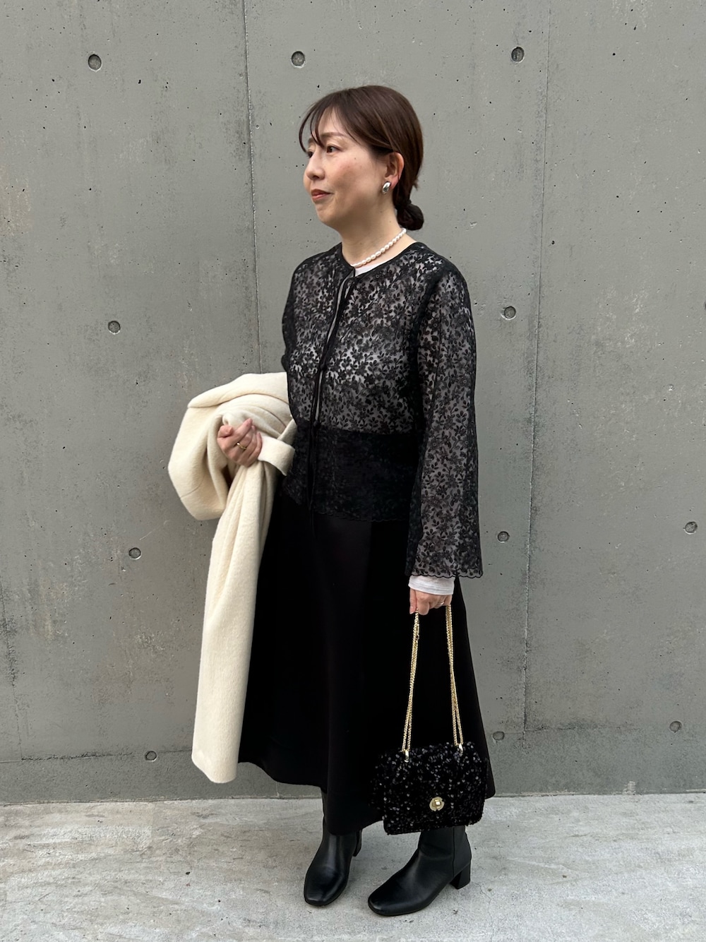 ブラック系のシャツ/ブラウス、ブラック系のショルダーバッグ、ベージュ系のTシャツ/カットソーを着用したレディースの冬コーディネートの1枚目の写真