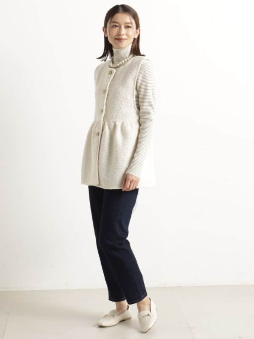 ベージュ系のベスト、ブラウン系のニット/セーター、ブルー系のその他パンツを着用したレディースの冬コーディネートの1枚目の写真