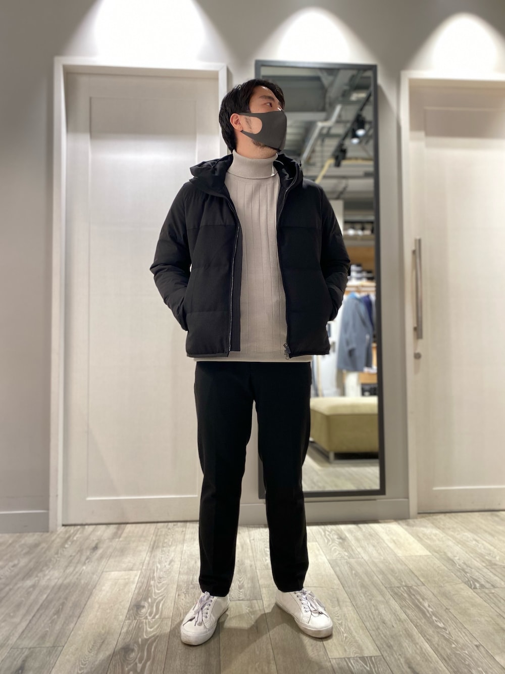 ベージュ系のニット/セーター、ブラック系のダウンジャケット/コート、ブラック系のスラックスを着用したメンズの冬コーディネートの1枚目の写真