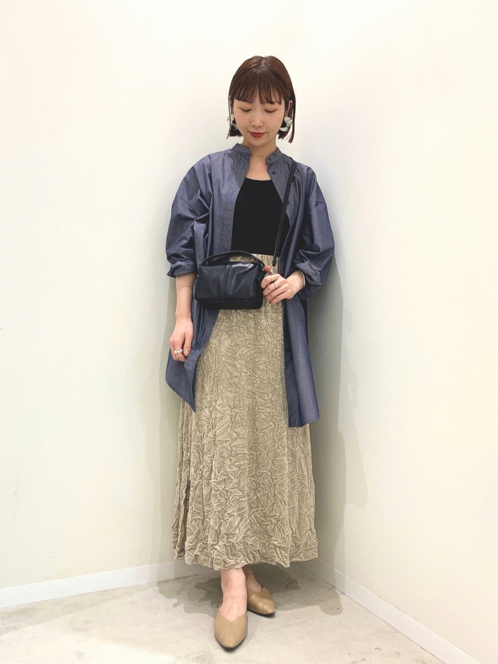 ブラック系のショルダーバッグ、ブルー系のシャツ/ブラウス、ベージュ系のスカートを着用したレディースの夏コーディネートの1枚目の写真