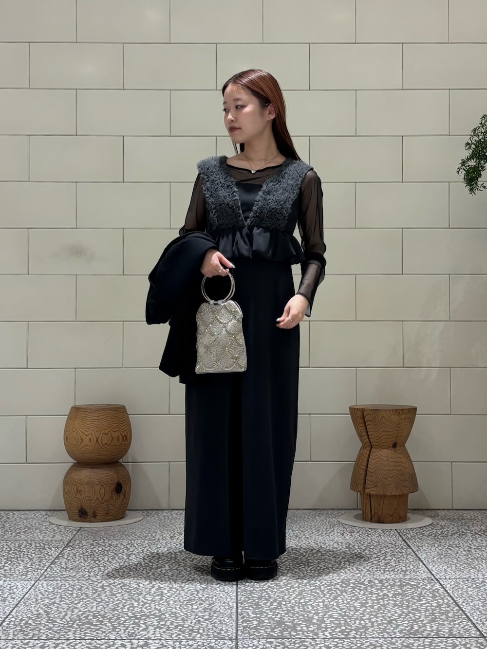 グレー系のドレス、ブラック系のテーラードジャケット、シルバー系のハンドバッグを着用したレディースの春コーディネートの1枚目の写真