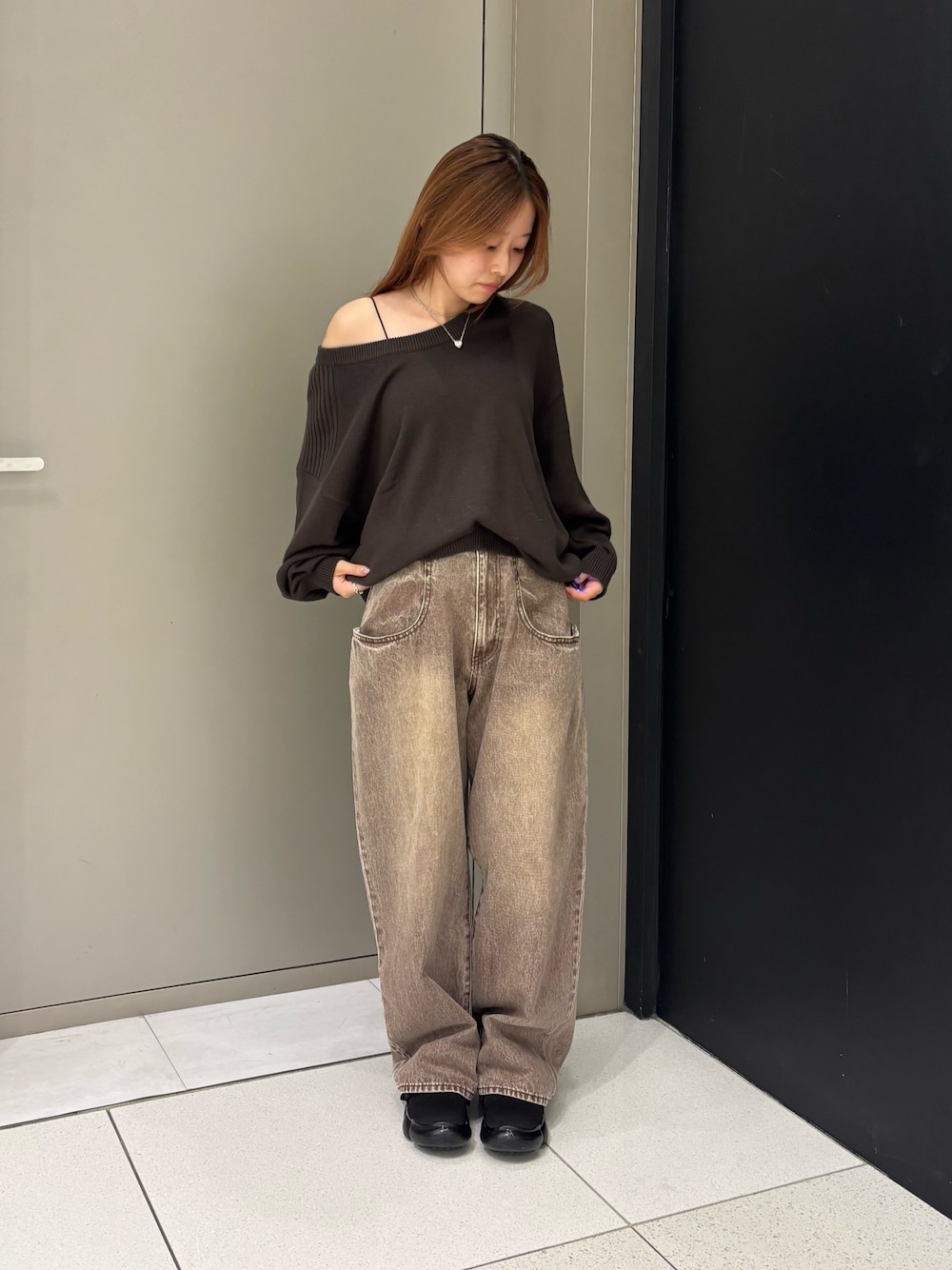 ブラウン系のニット/セーター、ブラウン系のデニムパンツを着用したレディースの秋コーディネートの1枚目の写真