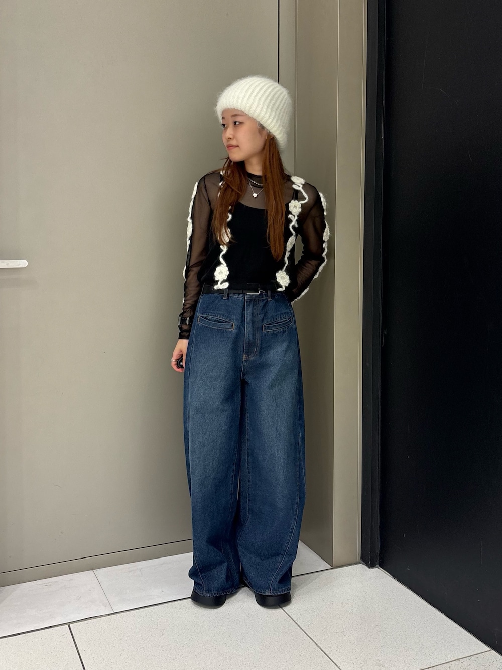 ブラック系のその他トップス、ブルー系のデニムパンツ、ブラック系のサンダルを着用したレディースの秋コーディネートの1枚目の写真