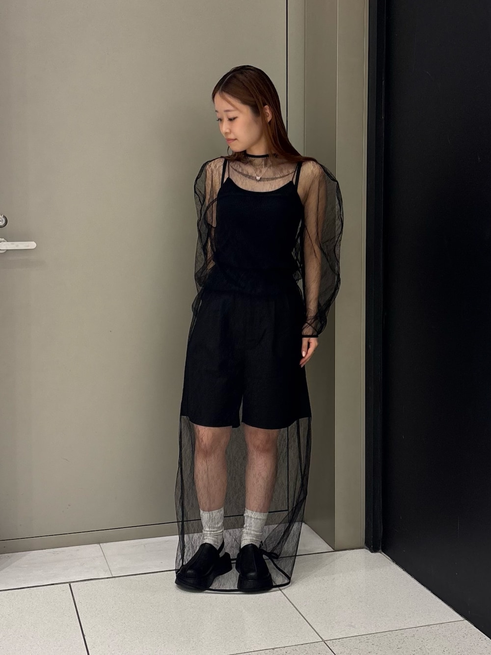 ブラック系のキャミソール、ブラック系のTシャツ/カットソー、ブラック系のスカートを着用したレディースの秋コーディネートの1枚目の写真