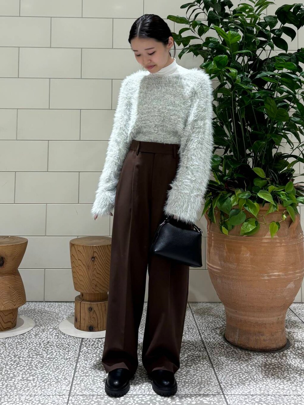 ブラウン系のその他パンツ、グレー系のニット/セーター、ブラック系のハンドバッグを着用したレディースの秋コーディネートの1枚目の写真