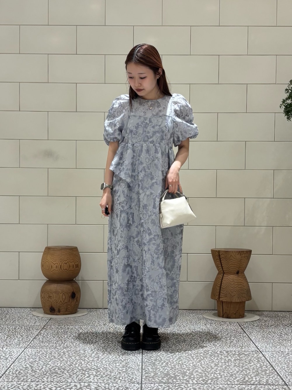 グレー系のドレス、ホワイト系のショルダーバッグを着用したレディースの春コーディネートの1枚目の写真