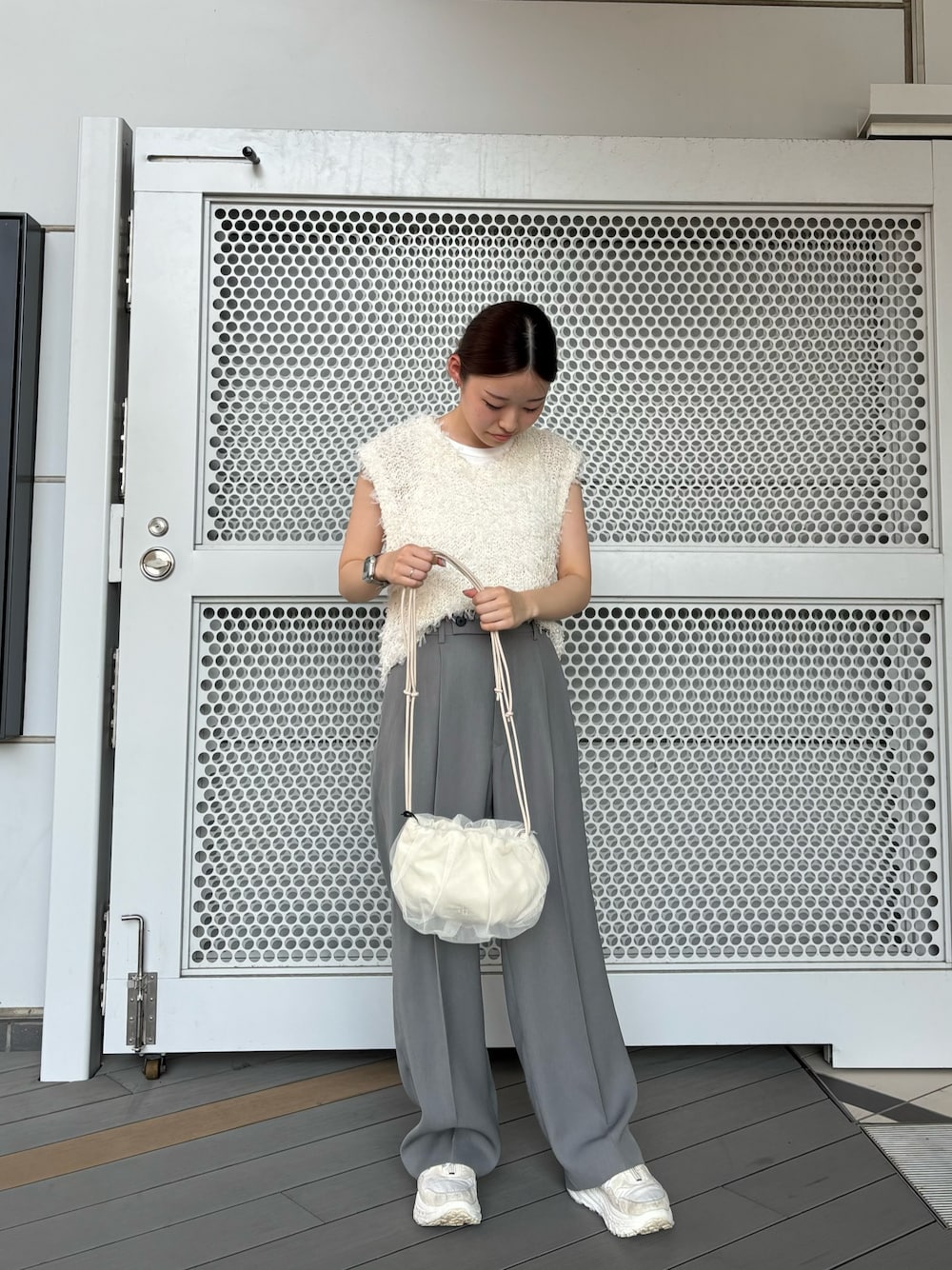 グレー系のその他パンツ、ホワイト系のショルダーバッグ、ホワイト系のベストを着用したレディースの夏コーディネートの1枚目の写真