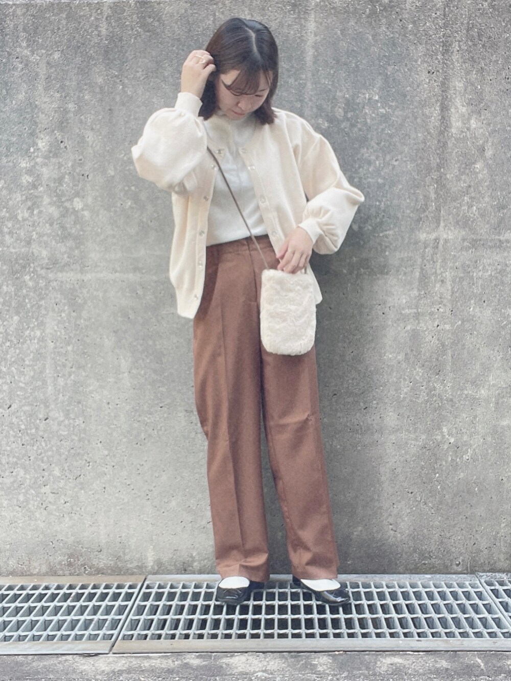 ホワイト系のTシャツ/カットソー、ホワイト系のカーディガン/ボレロ、ブラウン系のその他パンツを着用したレディースの冬コーディネートの1枚目の写真