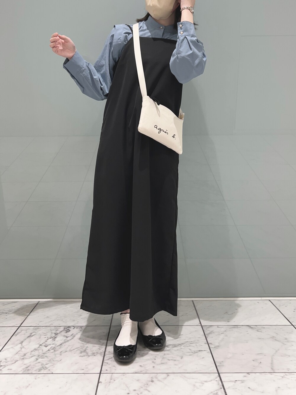 ブルー系のチュニック、ブラック系のワンピース/ドレス、ホワイト系のショルダーバッグを着用したレディースの春コーディネートの1枚目の写真