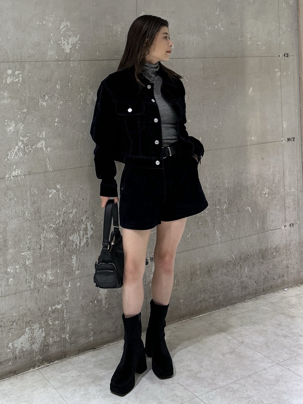 ブラック系のショルダーバッグ、ブラック系のブーツ、ブルー系のブルゾンを着用したレディースの秋コーディネートの1枚目の写真