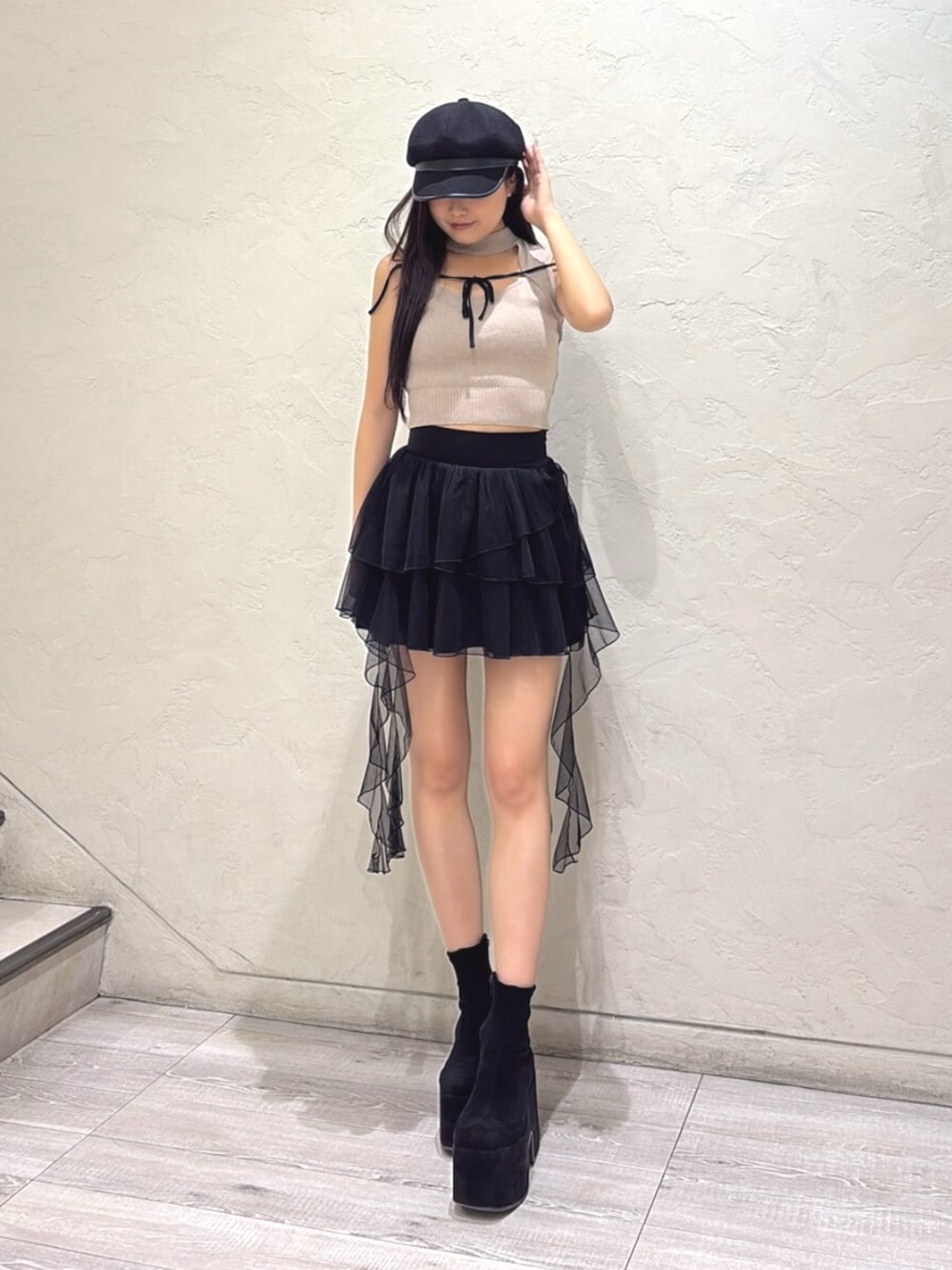 ブラック系のブーツ、ベージュ系のニット/セーター、ブラック系のスカートを着用したレディースの夏コーディネートの1枚目の写真