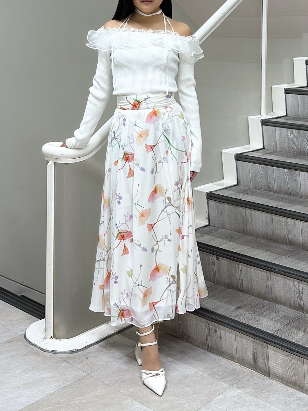 ホワイト系のニット/セーター、ホワイト系のスカート、ホワイト系のパンプスを着用したレディースの冬コーディネートの1枚目の写真