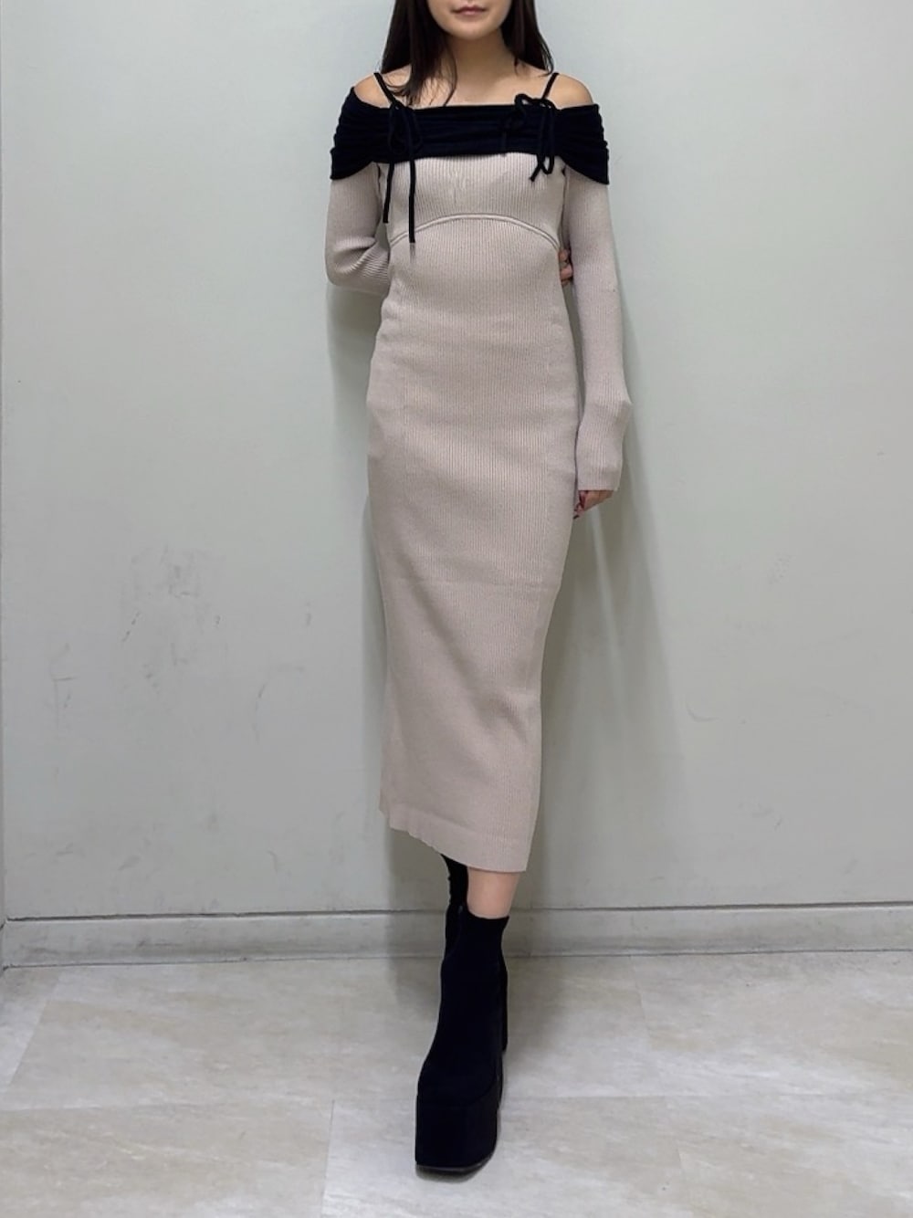 ベージュ系のワンピース、ブラック系のブーツを着用したレディースの秋コーディネートの1枚目の写真