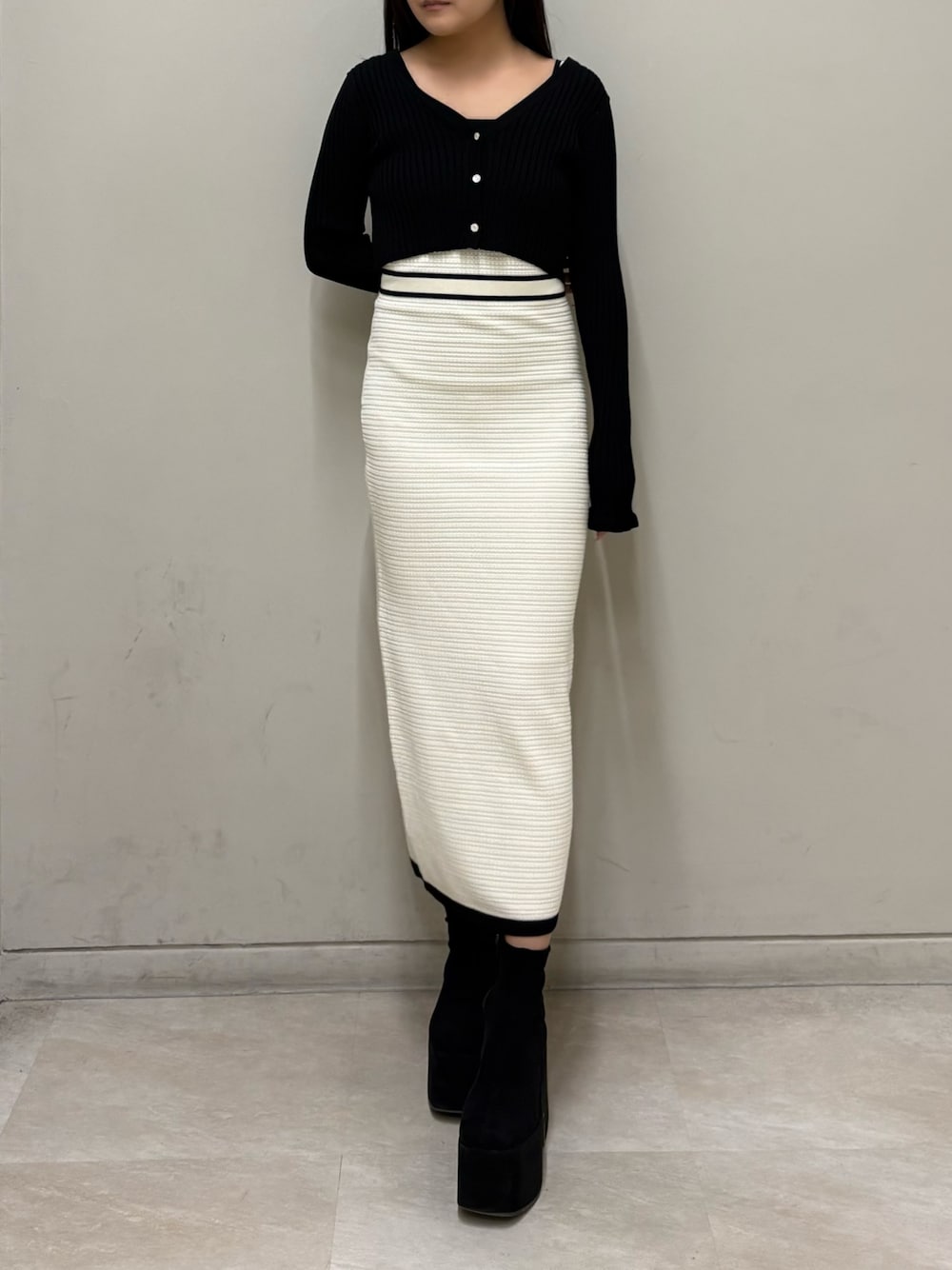 ホワイト系のワンピース、ブラック系のブーツを着用したレディースの春コーディネートの1枚目の写真