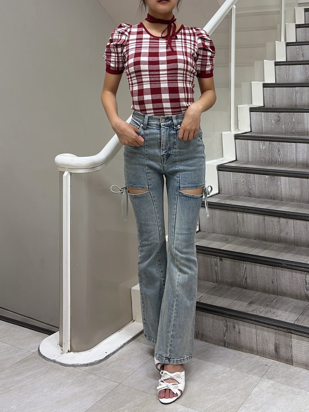レッド系のニット/セーター、ブルー系のデニムパンツ、ホワイト系のサンダルを着用したレディースの夏コーディネートの1枚目の写真