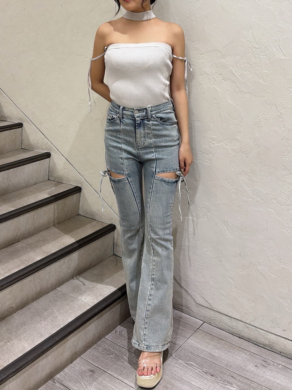 グレー系のニット/セーター、ブルー系のデニムパンツ、ホワイト系のサンダルを着用したレディースの春コーディネートの1枚目の写真
